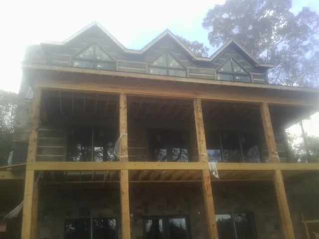 Dormers and porch framing on a large log home under construction — Roof Coating work by our crew in Franklin Park